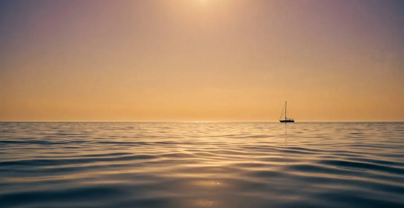 Navigation paisible au coucher du soleil avec mer d'huile et lumière dorée sur l'eau