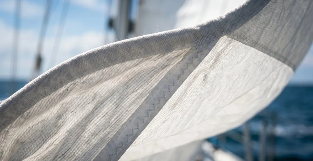 Gros plan sur le guindant d'un génois montrant les détails du tissu et le phénomène de faseyement